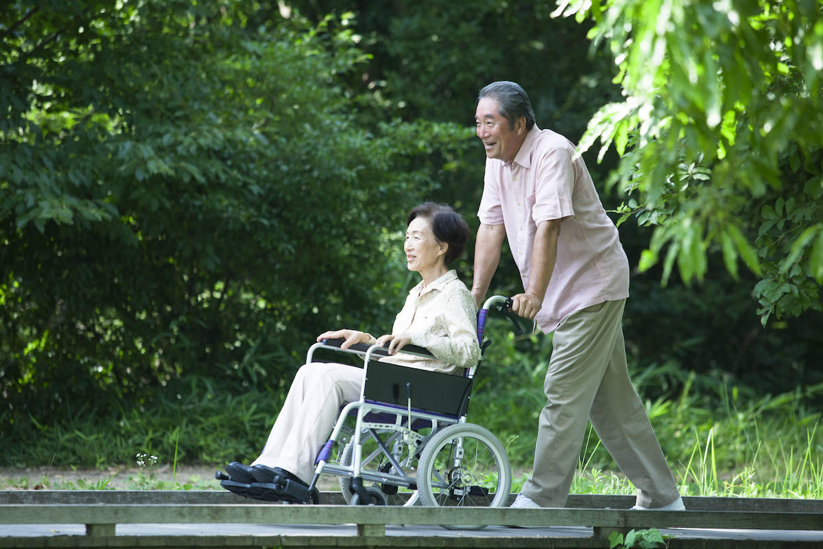 車椅子で散歩をする夫婦